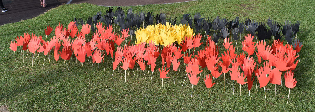 paper hands stuck on the ground to celebrate reconciliation week