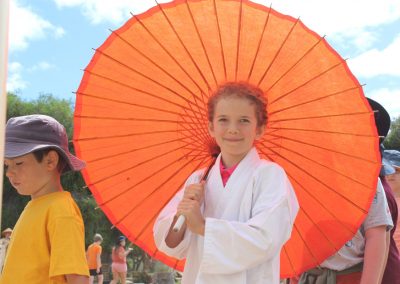 Student posing with orange color umbrella